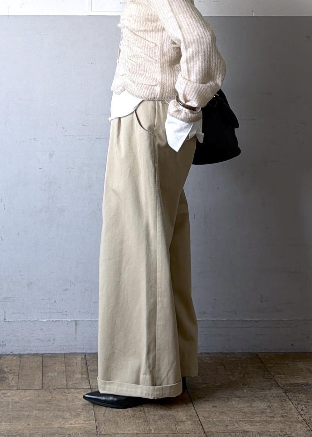 ベージュ系のカーディガン/ボレロ、ブラック系のブーツ、ホワイト系のTシャツ/カットソーを着用したレディースの冬コーディネートの10枚目の写真