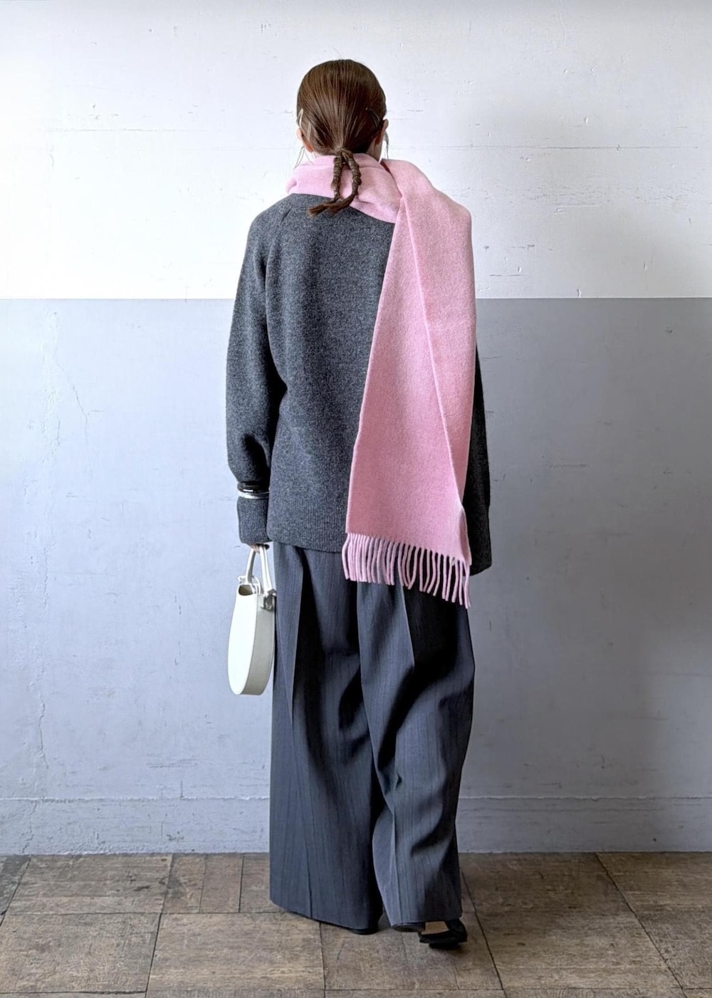 ホワイト系のハンドバッグ、グレー系のスラックス、グレー系のニット/セーターを着用したレディースの秋コーディネートの5枚目の写真