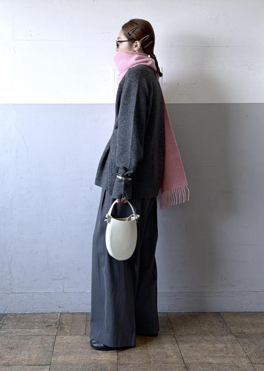 ホワイト系のハンドバッグ、グレー系のスラックス、グレー系のニット/セーターを着用したレディースの秋コーディネートの4枚目の写真