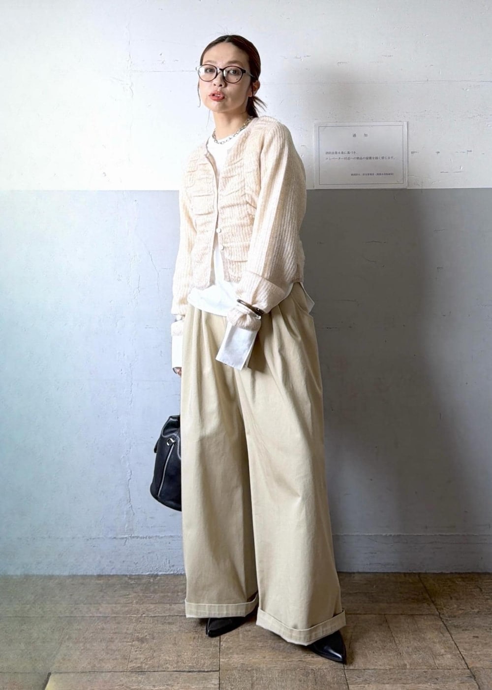 ベージュ系のカーディガン/ボレロ、ブラック系のブーツ、ホワイト系のTシャツ/カットソーを着用したレディースの冬コーディネートの3枚目の写真