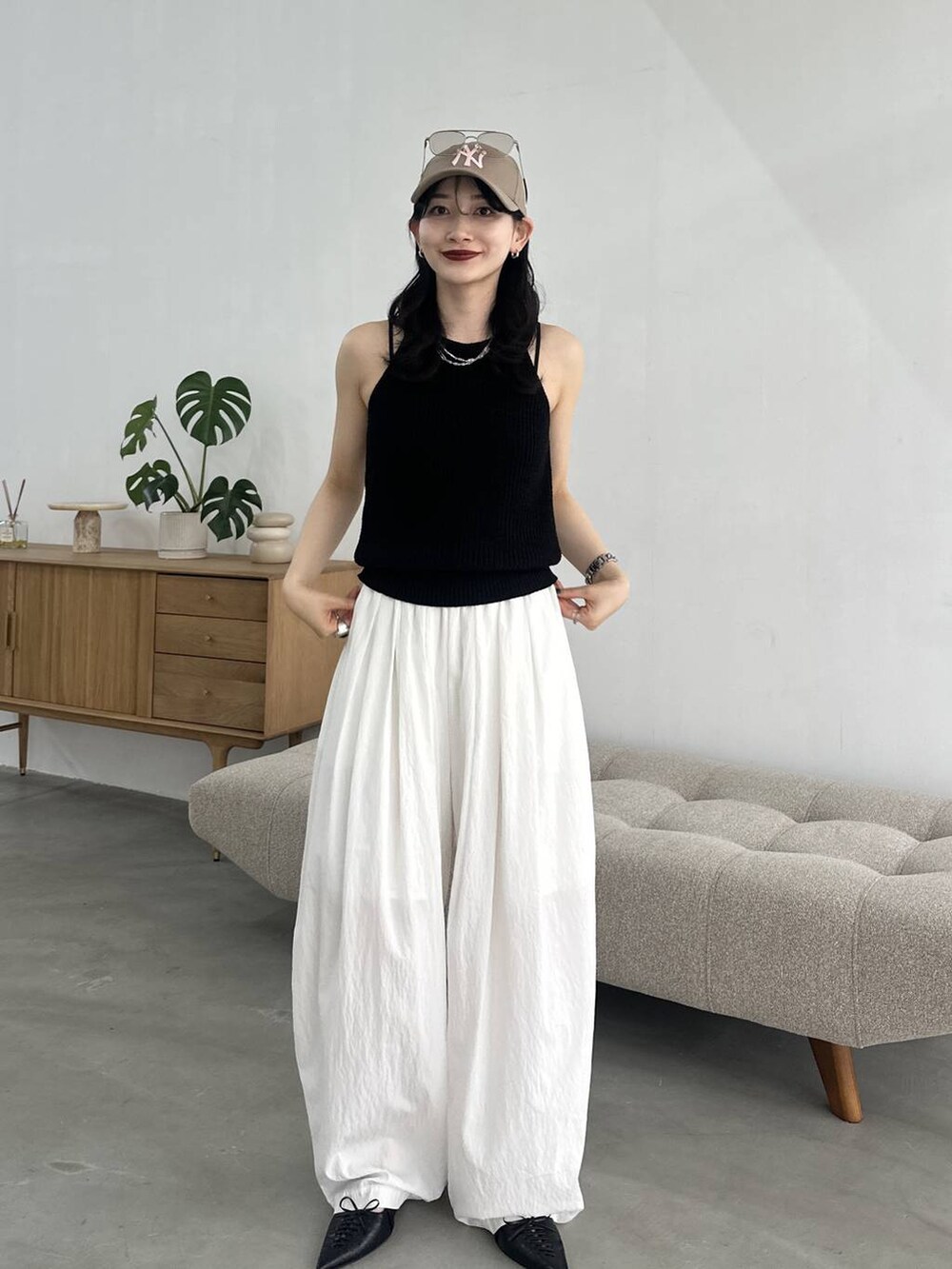 ブラック系のパンプス、ホワイト系のカーゴパンツ、ブラック系のタンクトップを着用したレディースの春コーディネートの3枚目の写真