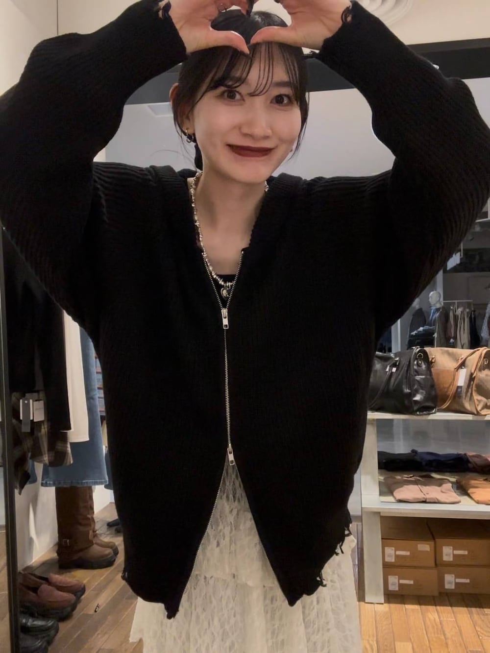 ブラック系のパーカー、ホワイト系のスカート、シルバー系のネックレスを着用したレディースの秋コーディネートの2枚目の写真