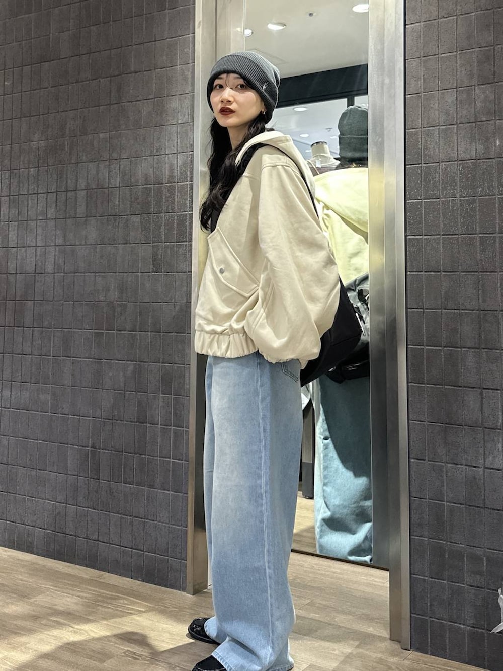 ブラック系のショルダーバッグ、ブラック系のローファー、ブルー系のデニムパンツを着用したレディースの春コーディネートの2枚目の写真