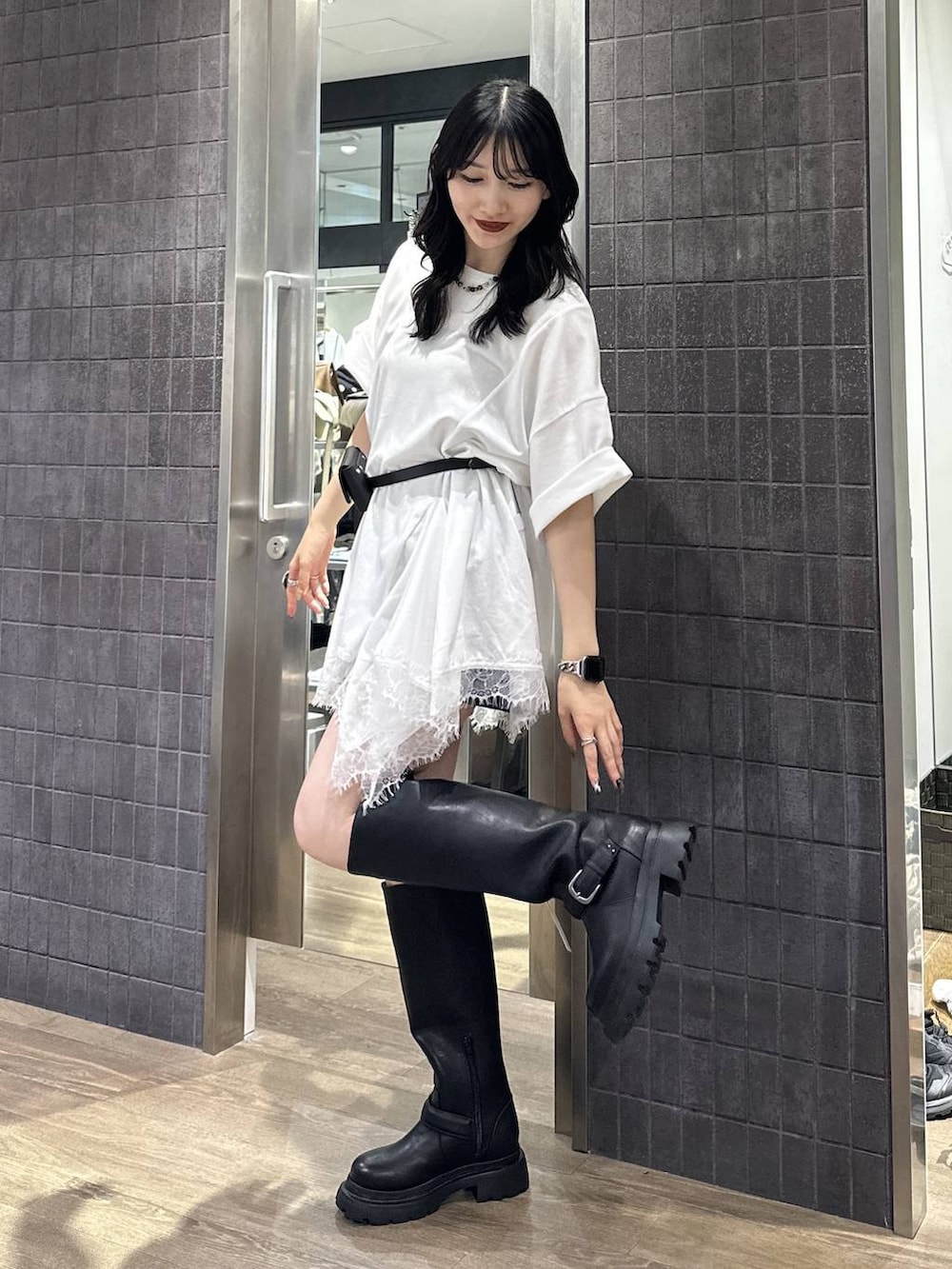 ブラック系のその他パンツ、ホワイト系のチュニック、ブラック系のブーツを着用したレディースの夏コーディネートの2枚目の写真