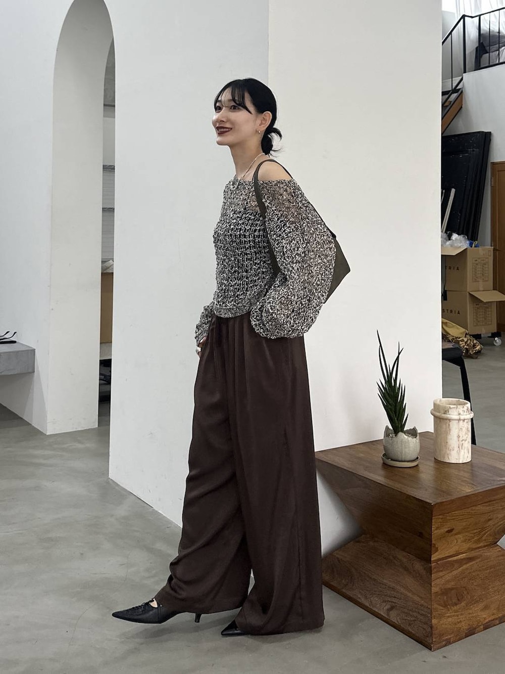 ブラック系のパンプス、ブラック系のニット/セーター、ブラウン系のその他パンツを着用したレディースの春コーディネートの3枚目の写真