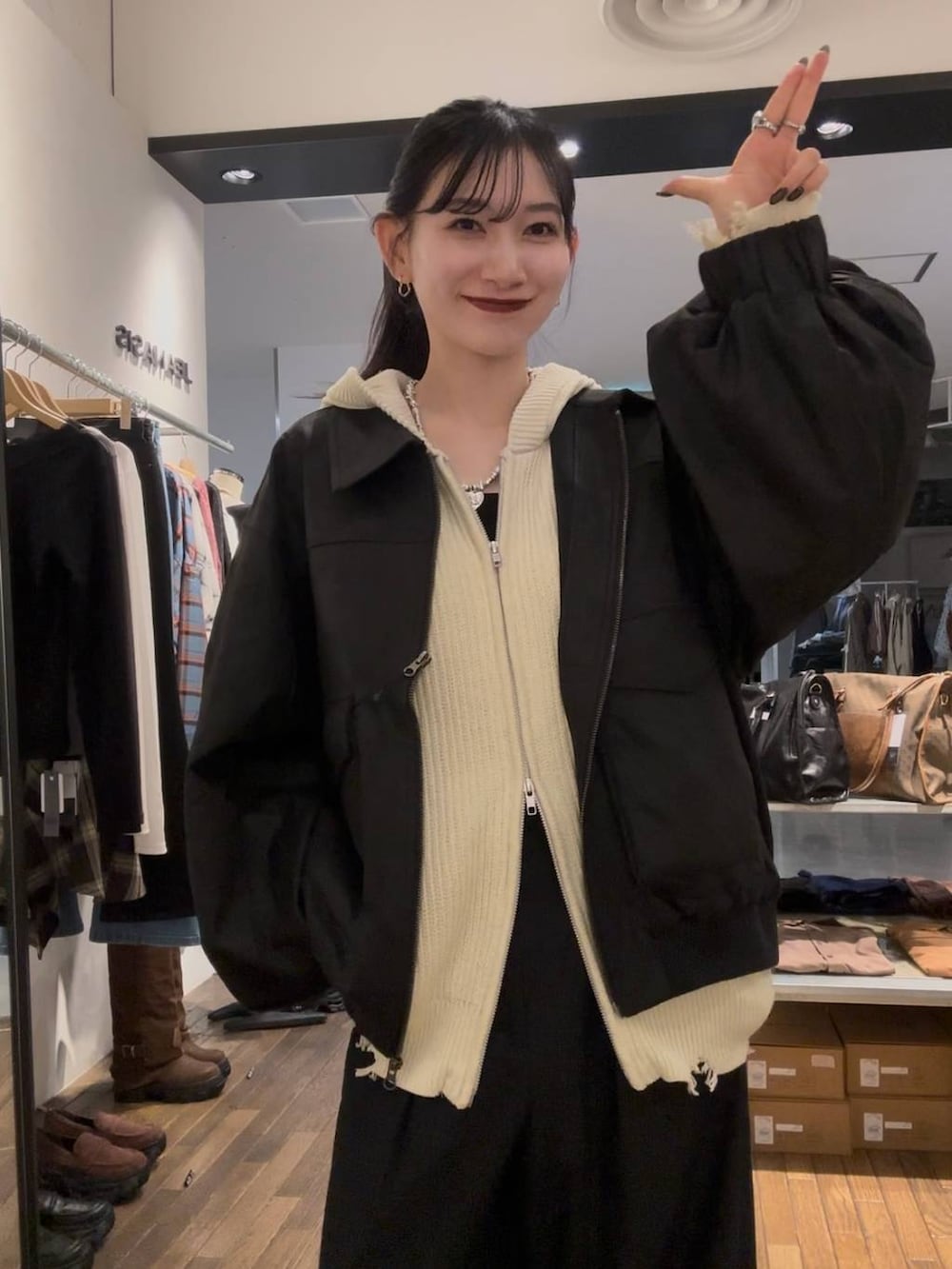 ブラック系のブルゾン、ブラック系のスラックス、ホワイト系のパーカーを着用したレディースの秋コーディネートの2枚目の写真