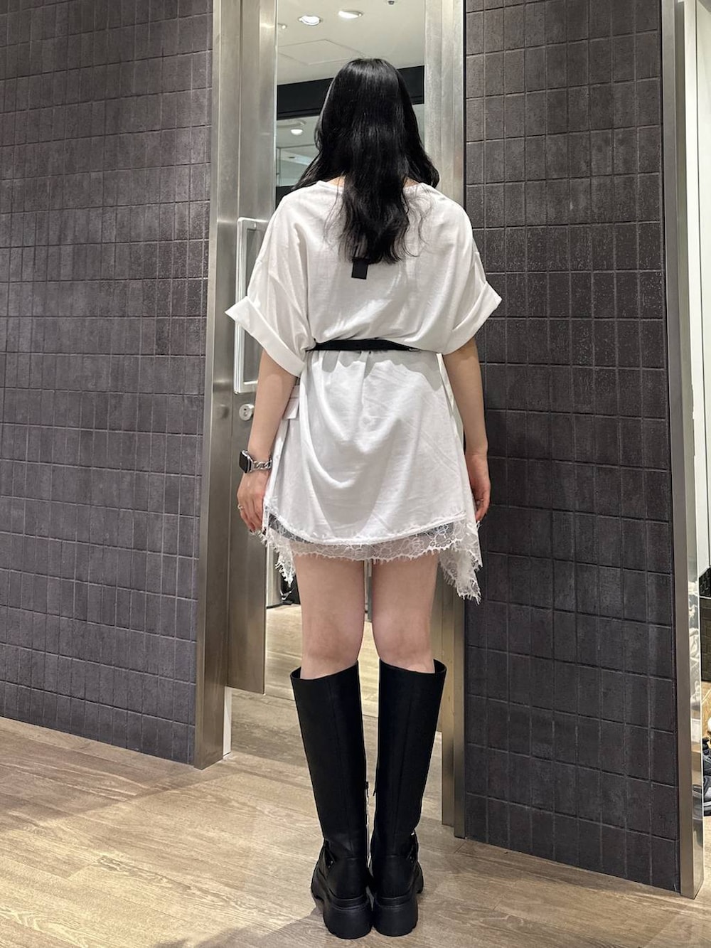 ブラック系のその他パンツ、ホワイト系のチュニック、ブラック系のブーツを着用したレディースの夏コーディネートの3枚目の写真