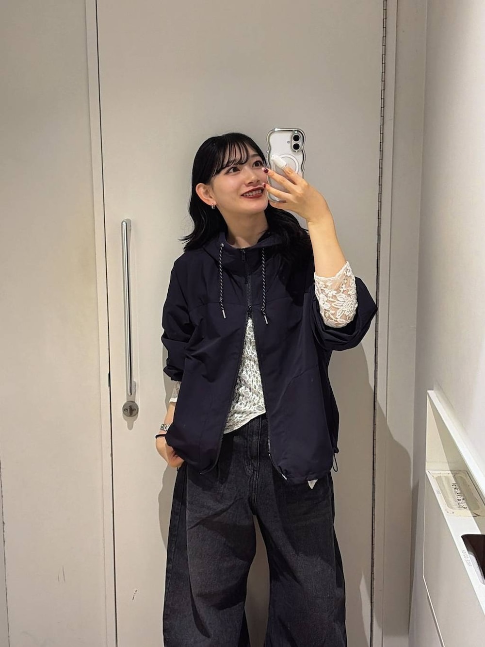 ブラック系のマウンテンパーカー、ブラック系のデニムパンツを着用したレディースの秋コーディネートの3枚目の写真