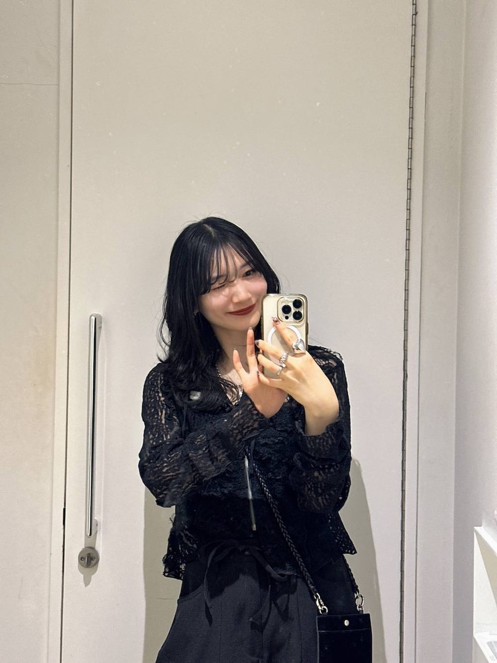 ブラック系のパーカー、ブラック系のスラックスを着用したレディースの春コーディネートの4枚目の写真