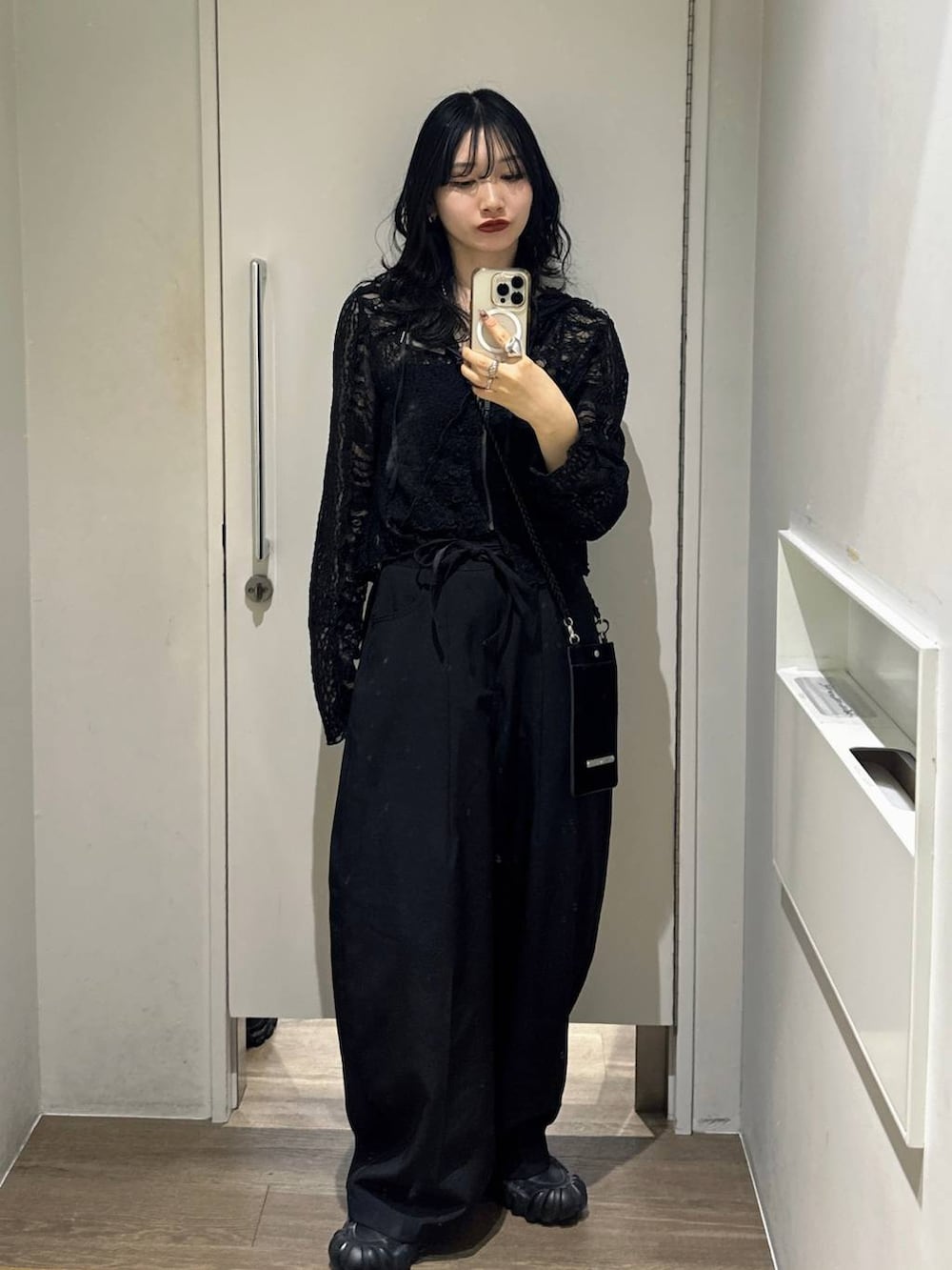 ブラック系のパーカー、ブラック系のスラックスを着用したレディースの春コーディネートの2枚目の写真