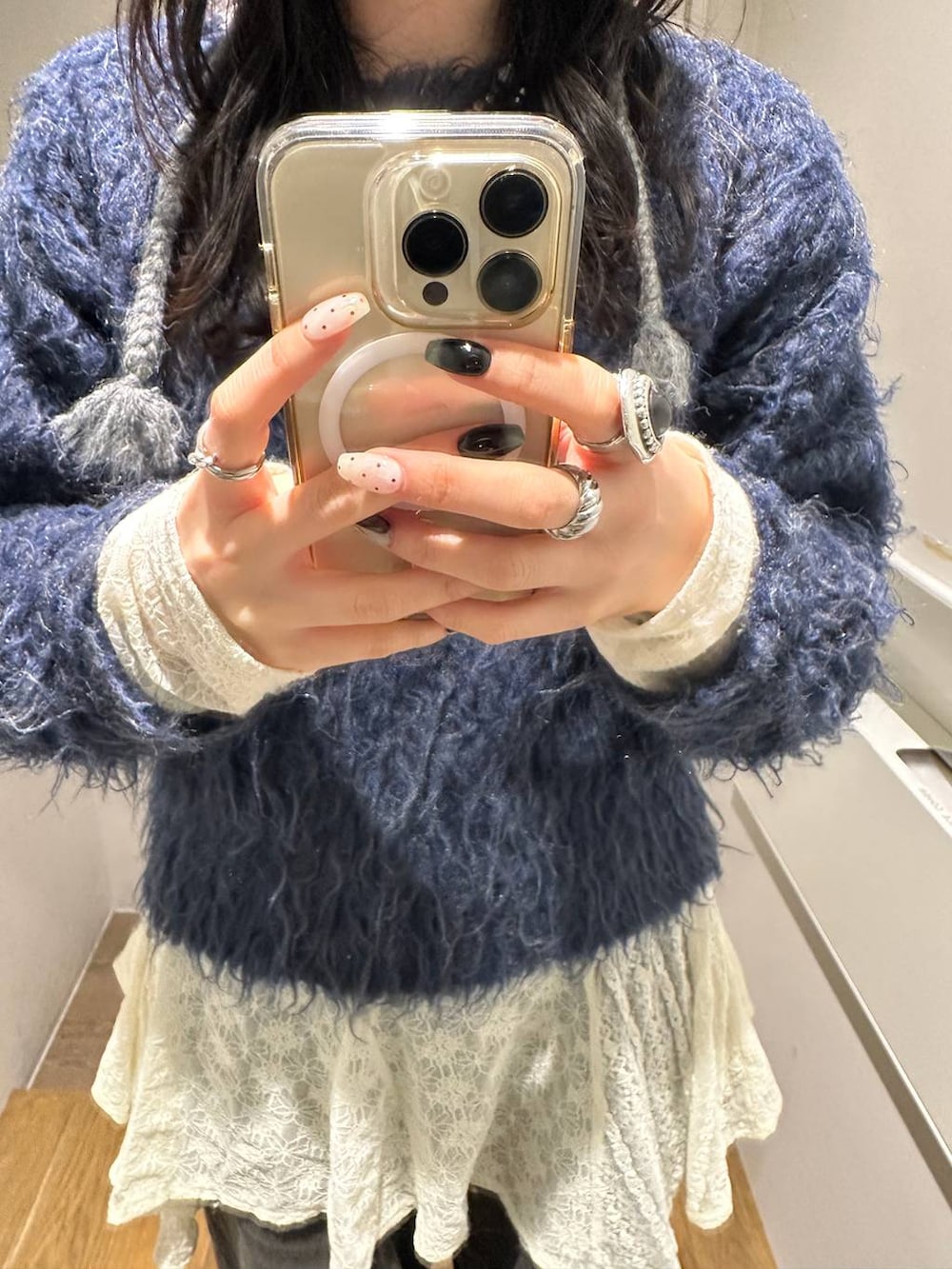 ホワイト系のワンピース、ブルー系のカーディガン/ボレロ、ブラック系のデニムパンツを着用したレディースの冬コーディネートの3枚目の写真