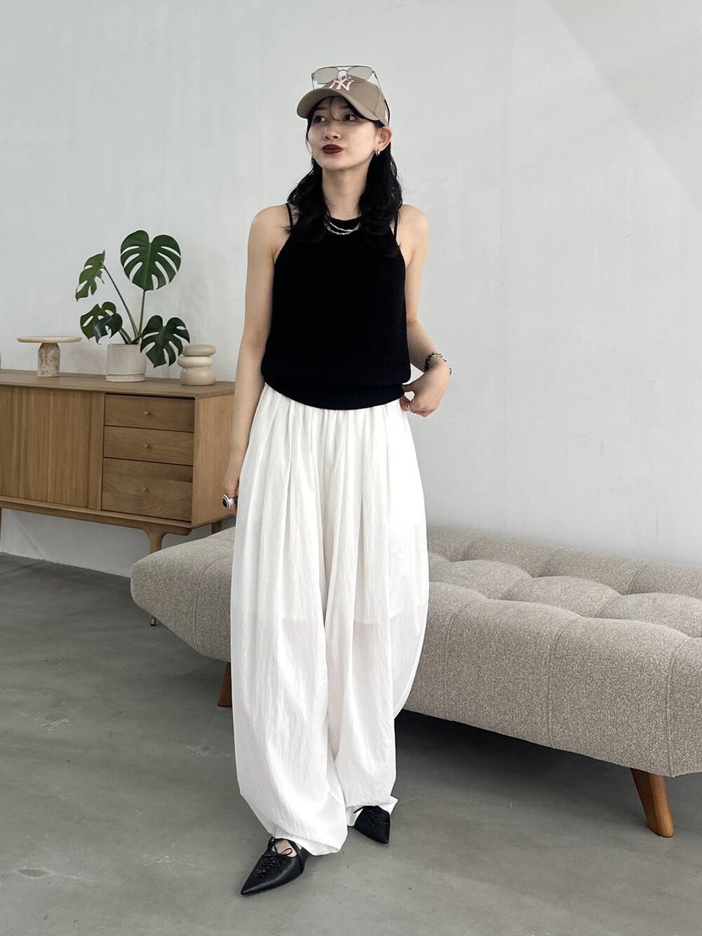 ブラック系のパンプス、ホワイト系のカーゴパンツ、ブラック系のタンクトップを着用したレディースの春コーディネートの2枚目の写真