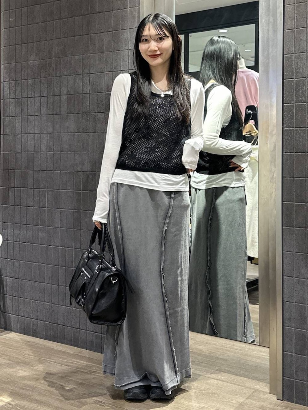 ホワイト系のTシャツ/カットソー、ブラック系のボストンバッグ、グレー系のスカートを着用したレディースの春コーディネートの2枚目の写真