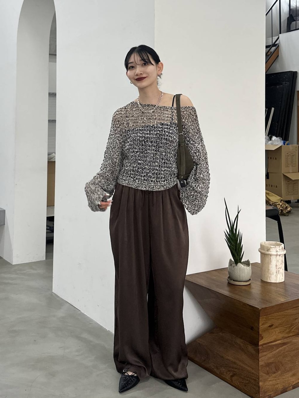 ブラック系のパンプス、ブラック系のニット/セーター、ブラウン系のその他パンツを着用したレディースの春コーディネートの4枚目の写真