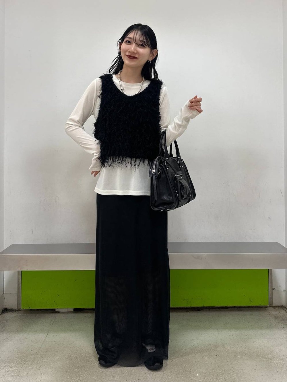 ブラック系のボストンバッグ、ブラック系のスカート、ホワイト系のTシャツ/カットソーを着用したレディースの夏コーディネートの3枚目の写真