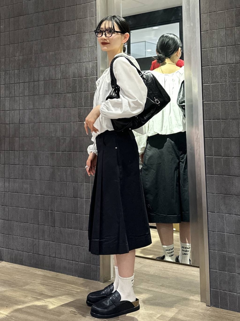 ブラック系のローファー、ブラック系のボストンバッグ、ブラック系のその他パンツを着用したレディースの春コーディネートの2枚目の写真