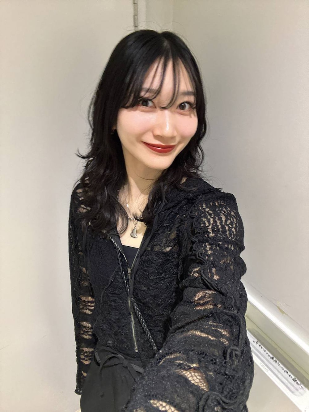 ブラック系のパーカー、ブラック系のスラックスを着用したレディースの春コーディネートの3枚目の写真