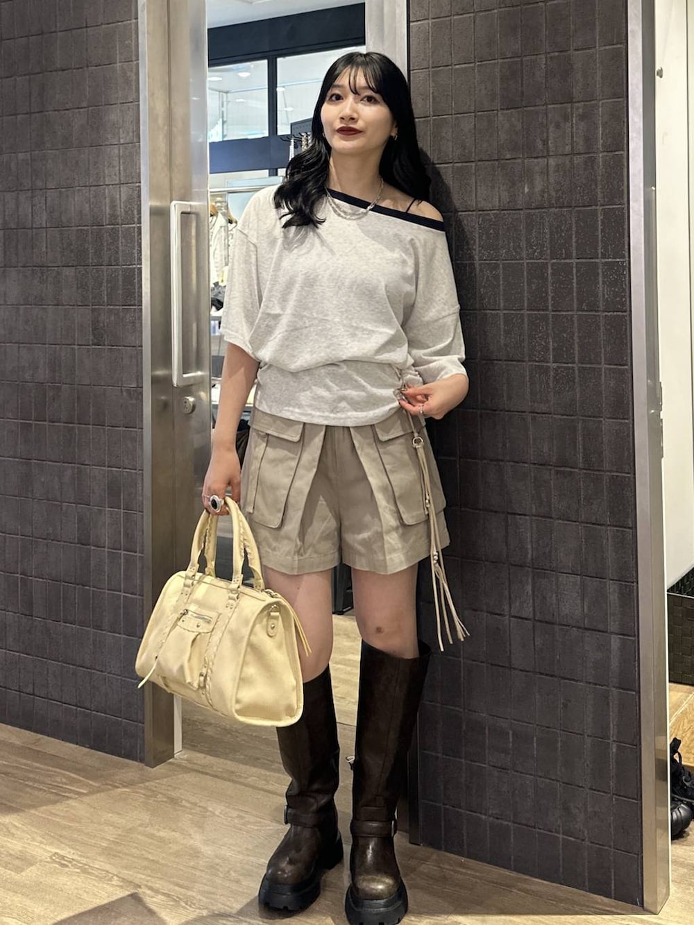 ベージュ系のカーゴパンツ、グレー系のTシャツ/カットソー、ベージュ系のボストンバッグを着用したレディースの夏コーディネートの3枚目の写真