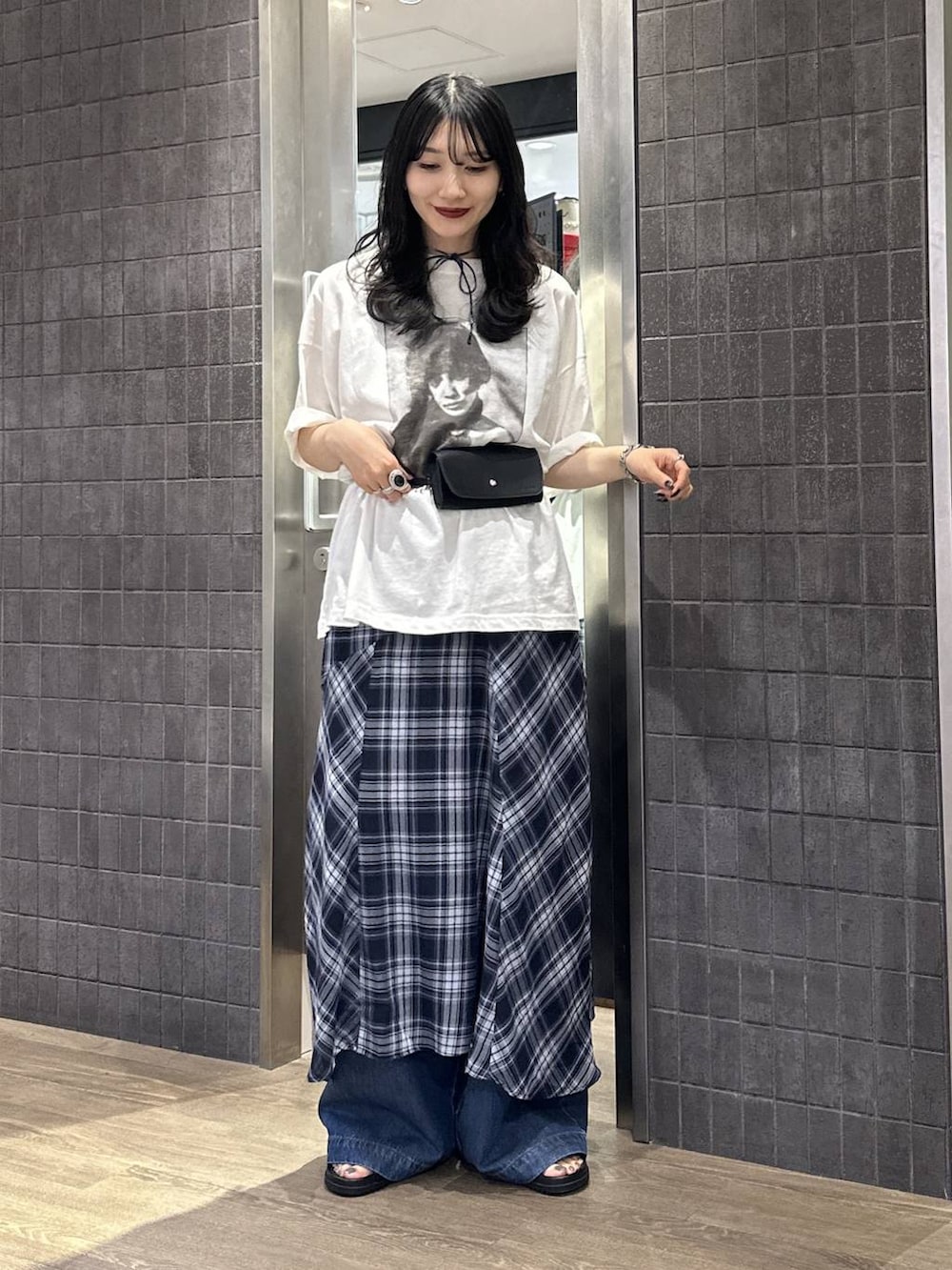 ブラック系のサンダル、ブルー系のワンピース、ブルー系のデニムパンツを着用したレディースの春コーディネートの3枚目の写真
