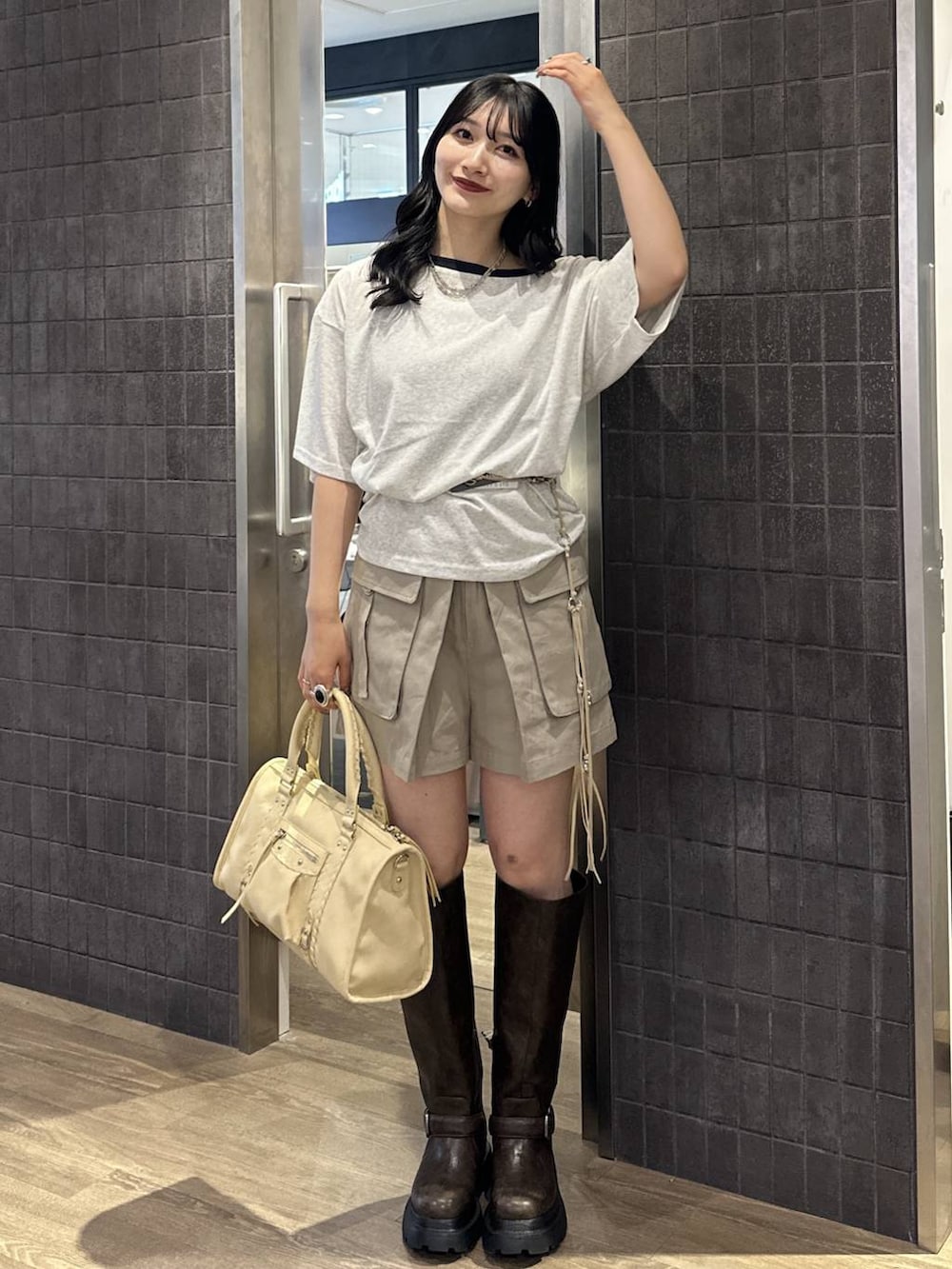 ベージュ系のカーゴパンツ、グレー系のTシャツ/カットソー、ベージュ系のボストンバッグを着用したレディースの夏コーディネートの2枚目の写真