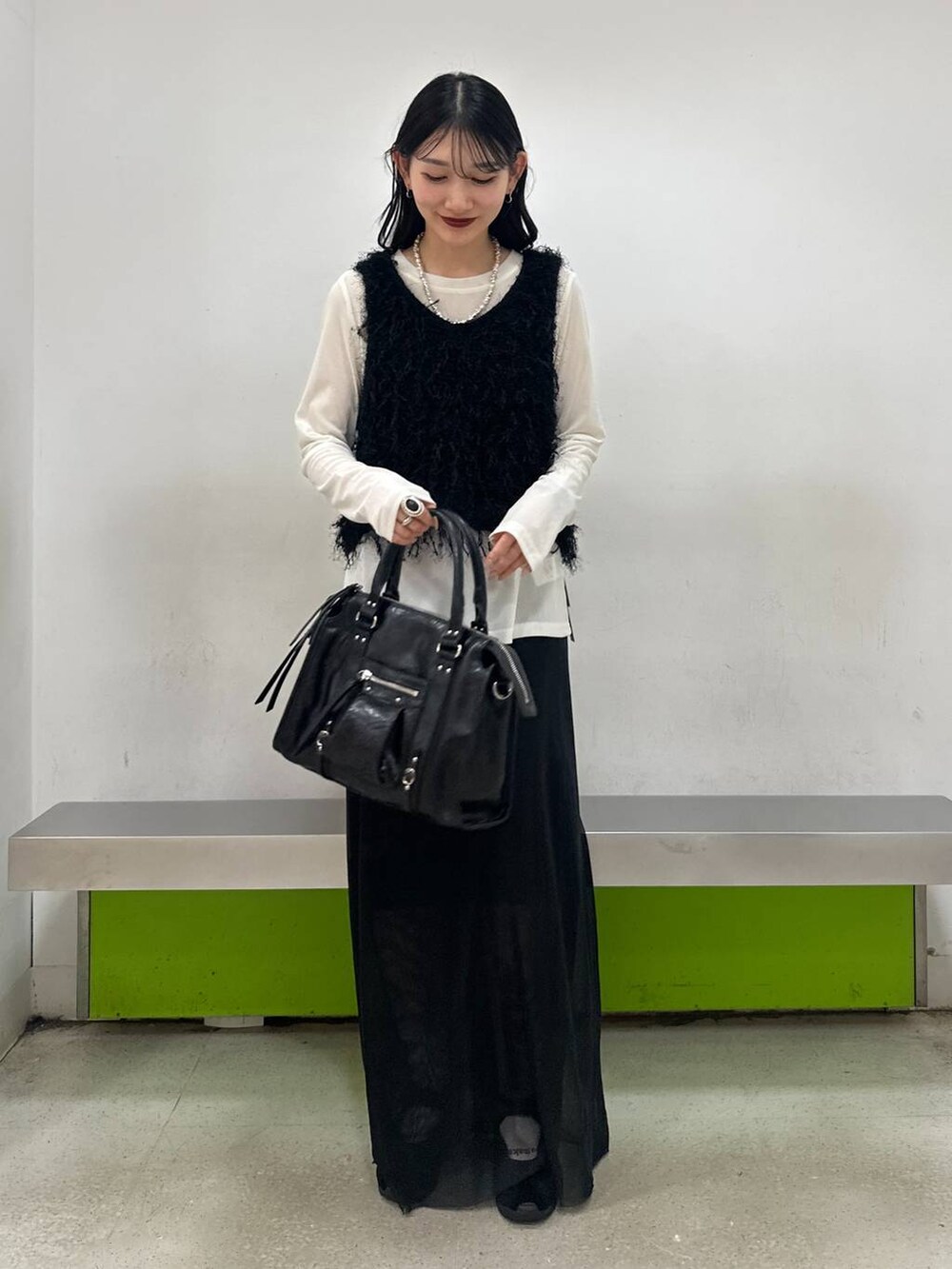 ブラック系のボストンバッグ、ブラック系のスカート、ホワイト系のTシャツ/カットソーを着用したレディースの夏コーディネートの2枚目の写真