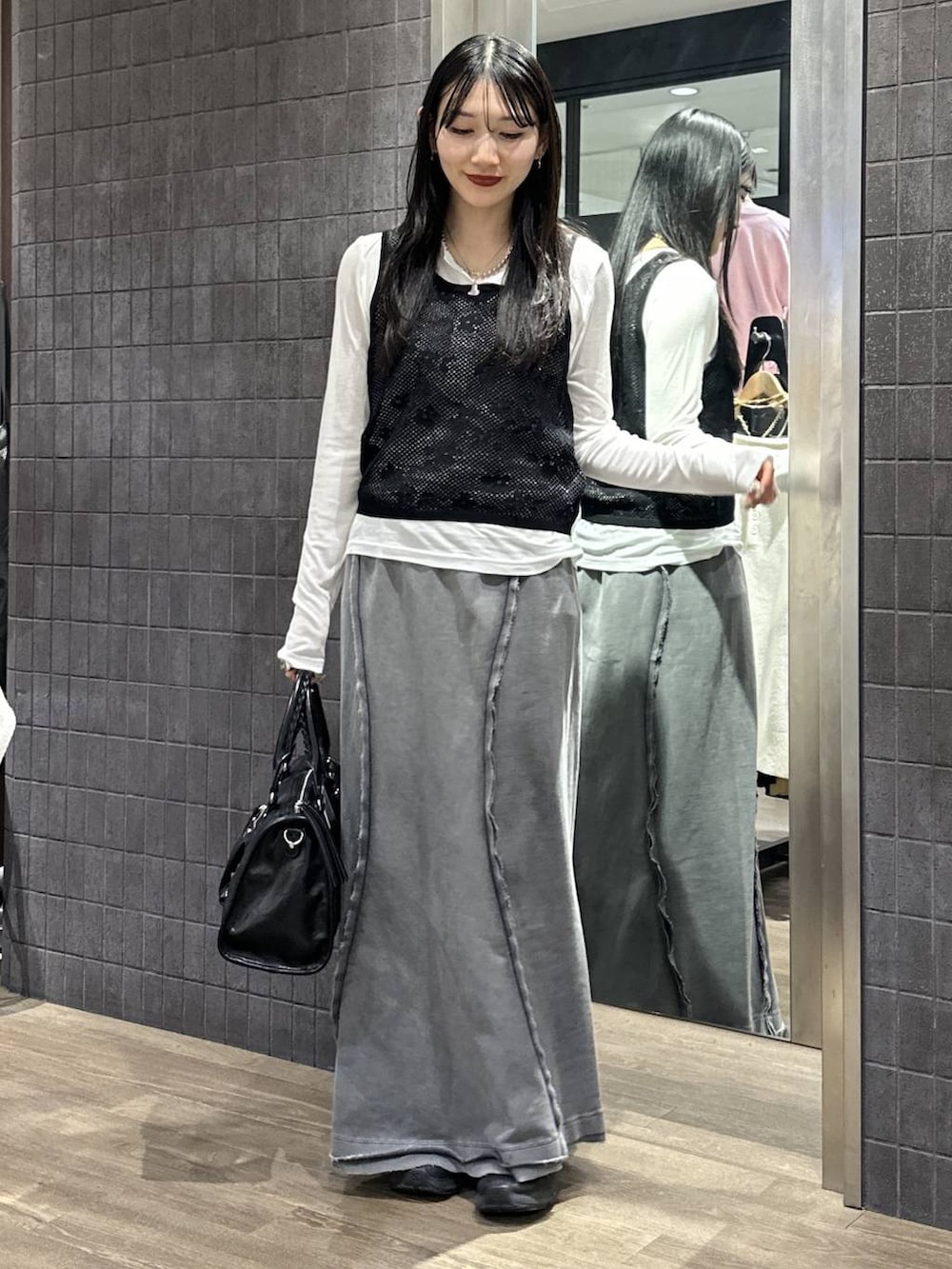 ホワイト系のTシャツ/カットソー、ブラック系のボストンバッグ、グレー系のスカートを着用したレディースの春コーディネートの3枚目の写真