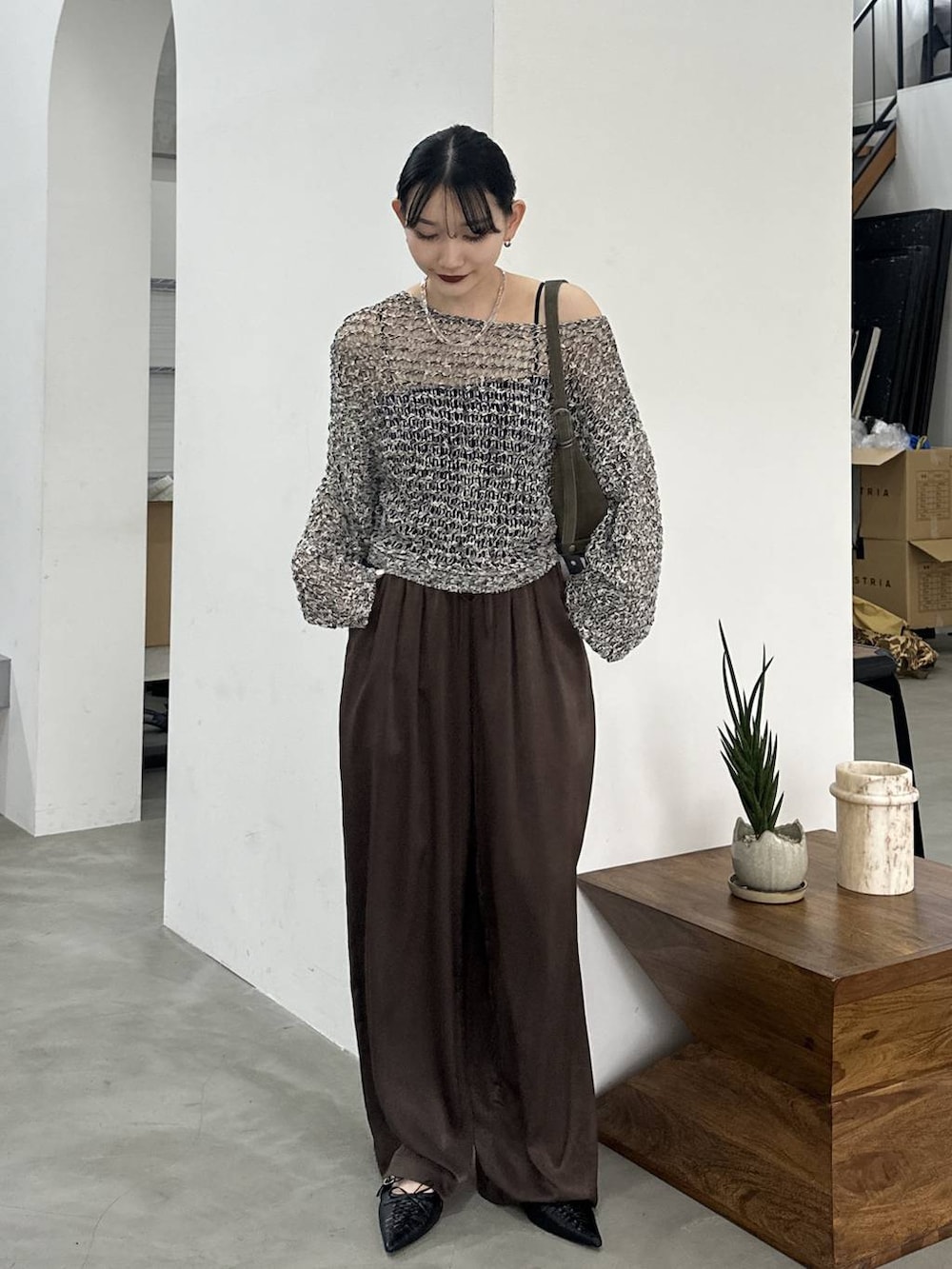 ブラック系のパンプス、ブラック系のニット/セーター、ブラウン系のその他パンツを着用したレディースの春コーディネートの2枚目の写真