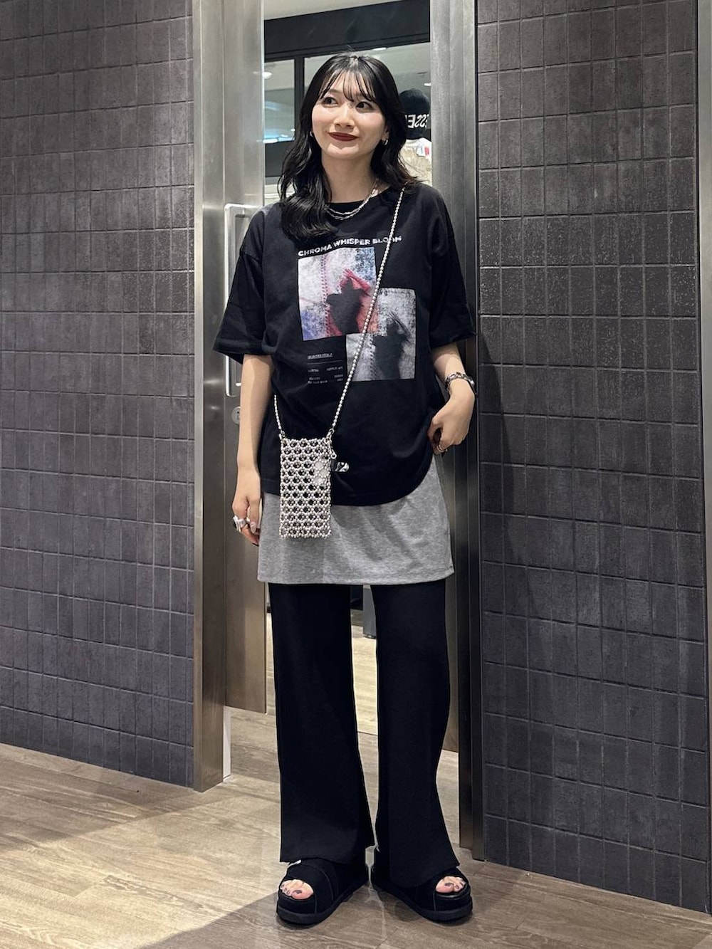 グレー系のスカート、ブラック系のスウェットパンツ、ブラック系のサンダルを着用したレディースの夏コーディネートの2枚目の写真