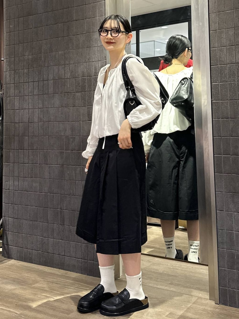 ブラック系のローファー、ブラック系のボストンバッグ、ブラック系のその他パンツを着用したレディースの春コーディネートの4枚目の写真