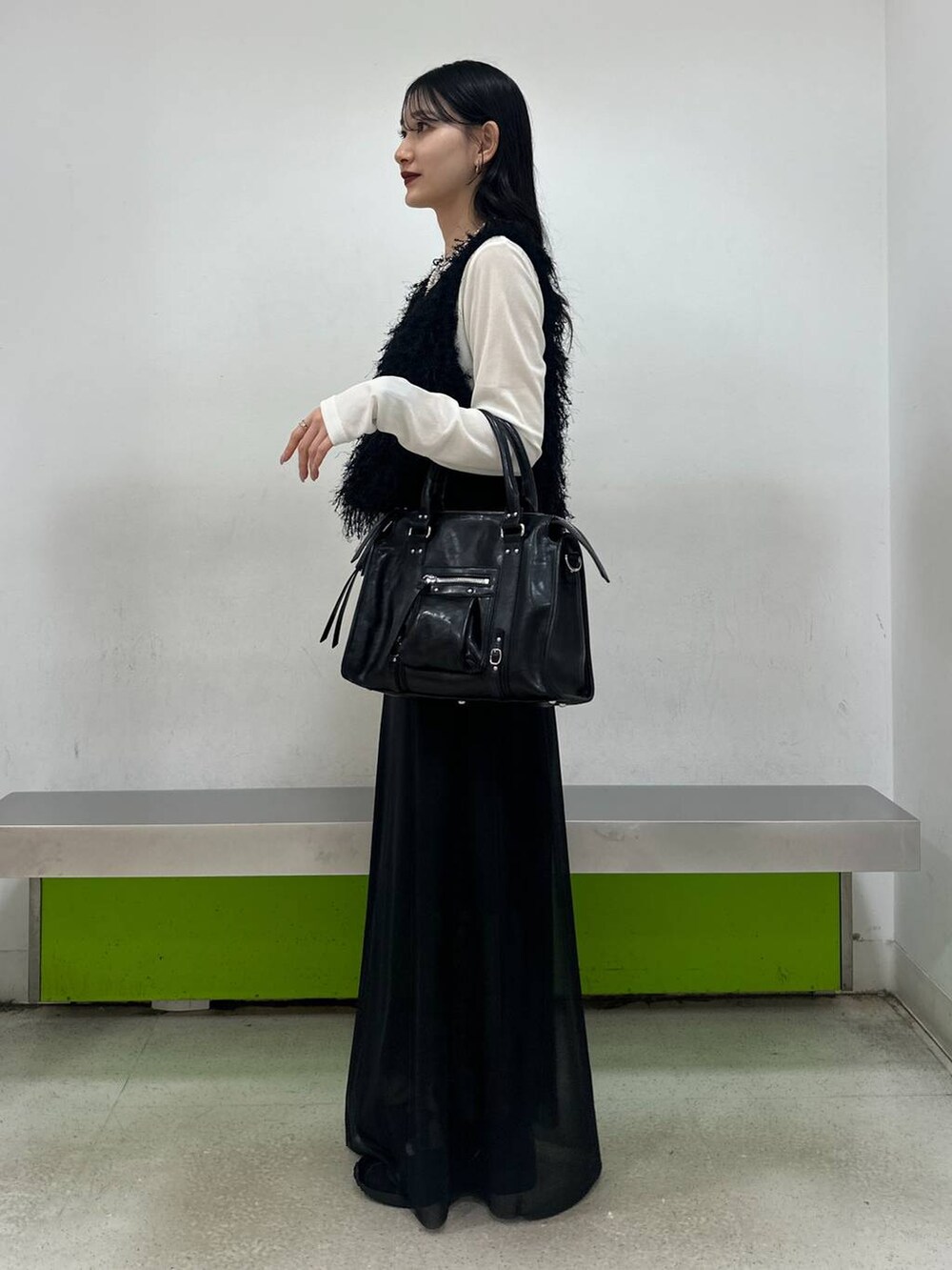 ブラック系のボストンバッグ、ブラック系のスカート、ホワイト系のTシャツ/カットソーを着用したレディースの夏コーディネートの4枚目の写真