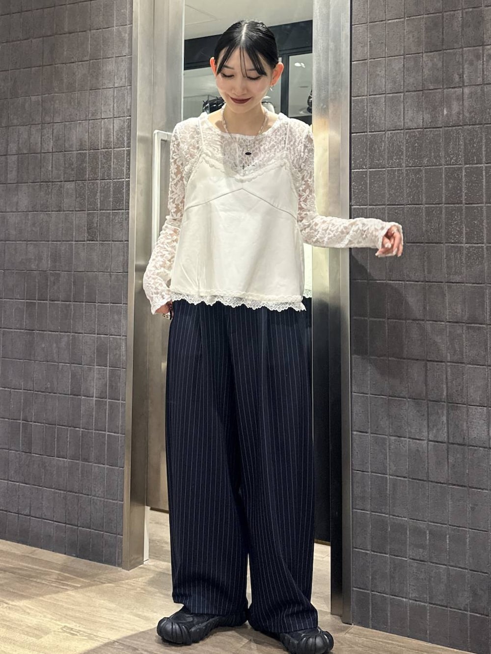 ブルー系のスラックス、ホワイト系のキャミソール、ホワイト系のTシャツ/カットソーを着用したレディースの冬コーディネートの3枚目の写真