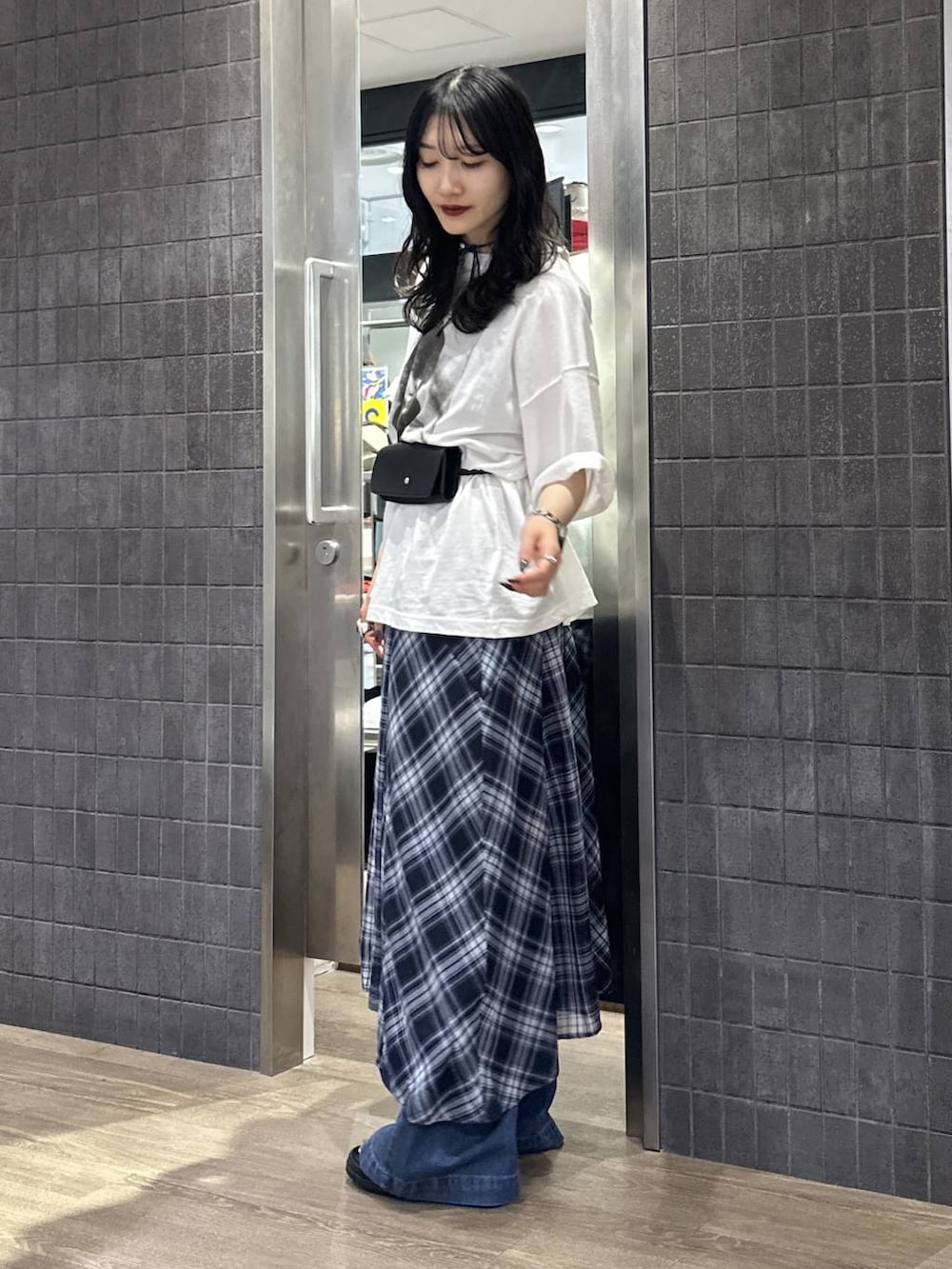 ブラック系のサンダル、ブルー系のワンピース、ブルー系のデニムパンツを着用したレディースの春コーディネートの2枚目の写真