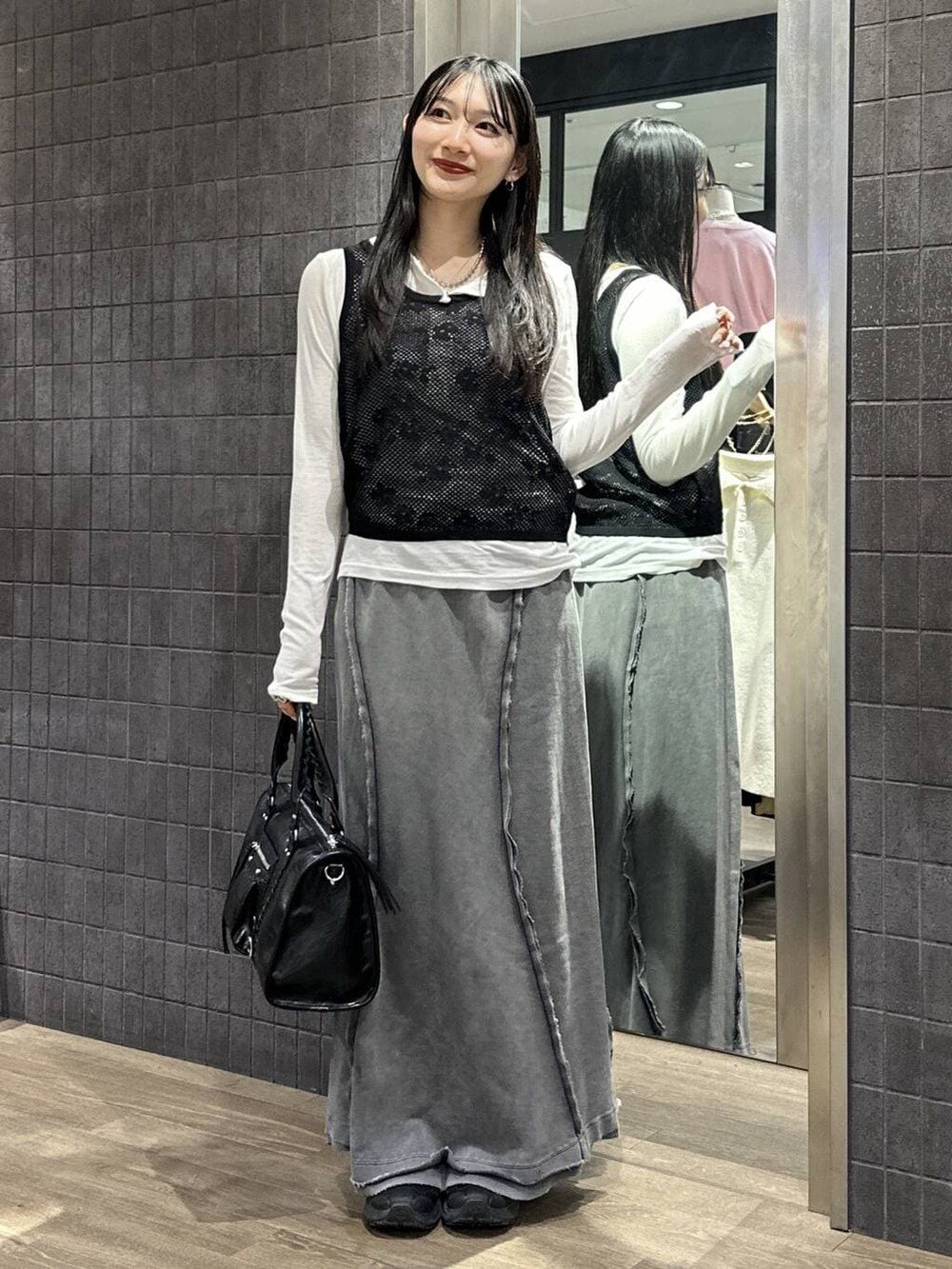 ホワイト系のTシャツ/カットソー、ブラック系のボストンバッグ、グレー系のスカートを着用したレディースの春コーディネートの4枚目の写真