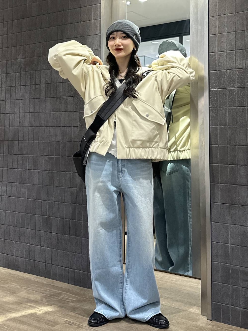 ブラック系のショルダーバッグ、ブラック系のローファー、ブルー系のデニムパンツを着用したレディースの春コーディネートの3枚目の写真