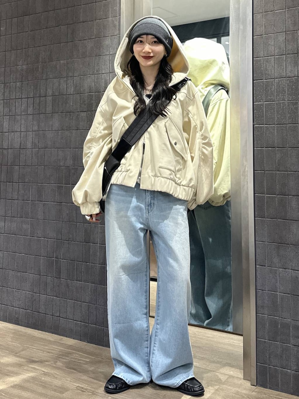 ブラック系のショルダーバッグ、ブラック系のローファー、ブルー系のデニムパンツを着用したレディースの春コーディネートの4枚目の写真