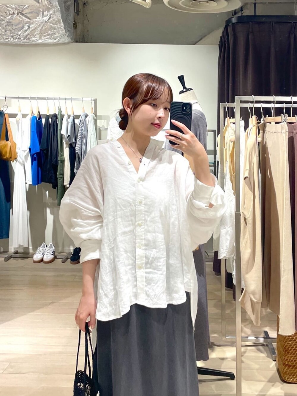 ホワイト系のシャツ/ブラウス、グレー系のスカート、ブラック系のサンダルを着用したレディースの夏コーディネートの2枚目の写真