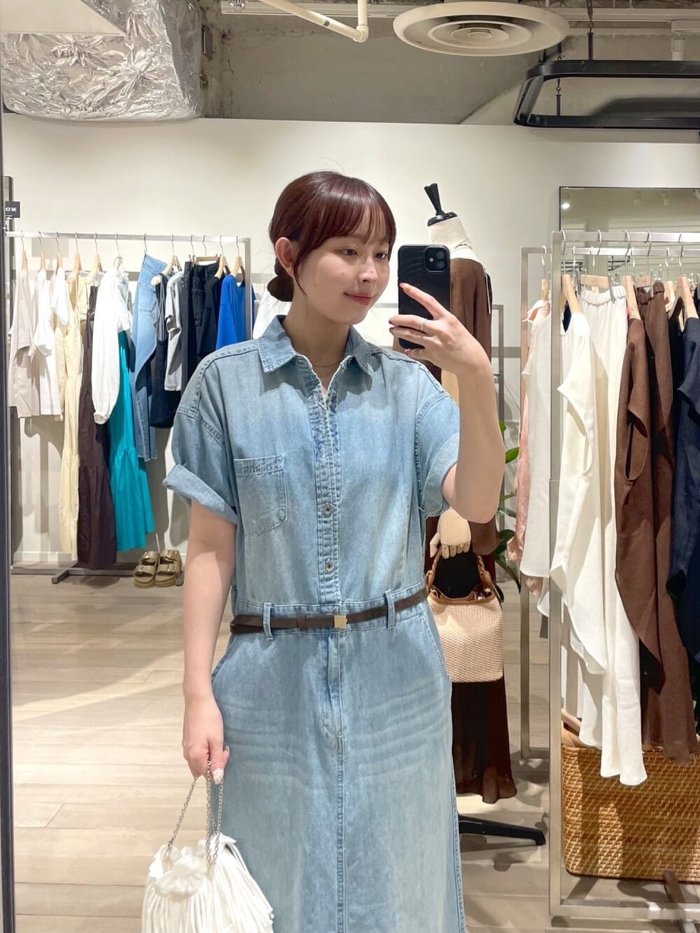 ブルー系のワンピース、ホワイト系のハンドバッグ、ブラウン系のパンプスを着用したレディースの夏コーディネートの2枚目の写真