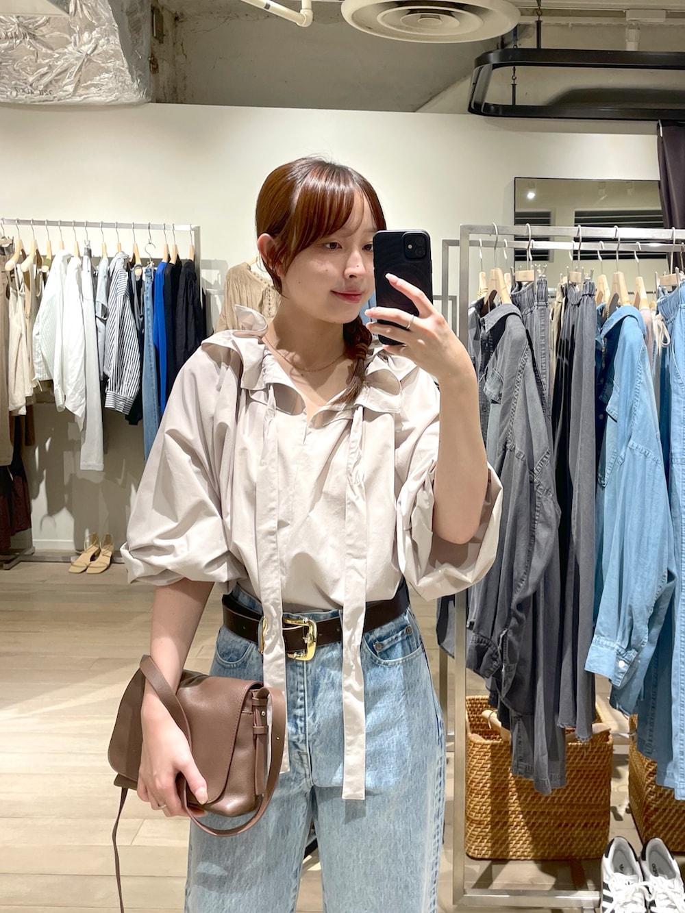 ベージュ系のシャツ/ブラウス、ブルー系のデニムパンツ、グレー系のパンプスを着用したレディースの夏コーディネートの2枚目の写真