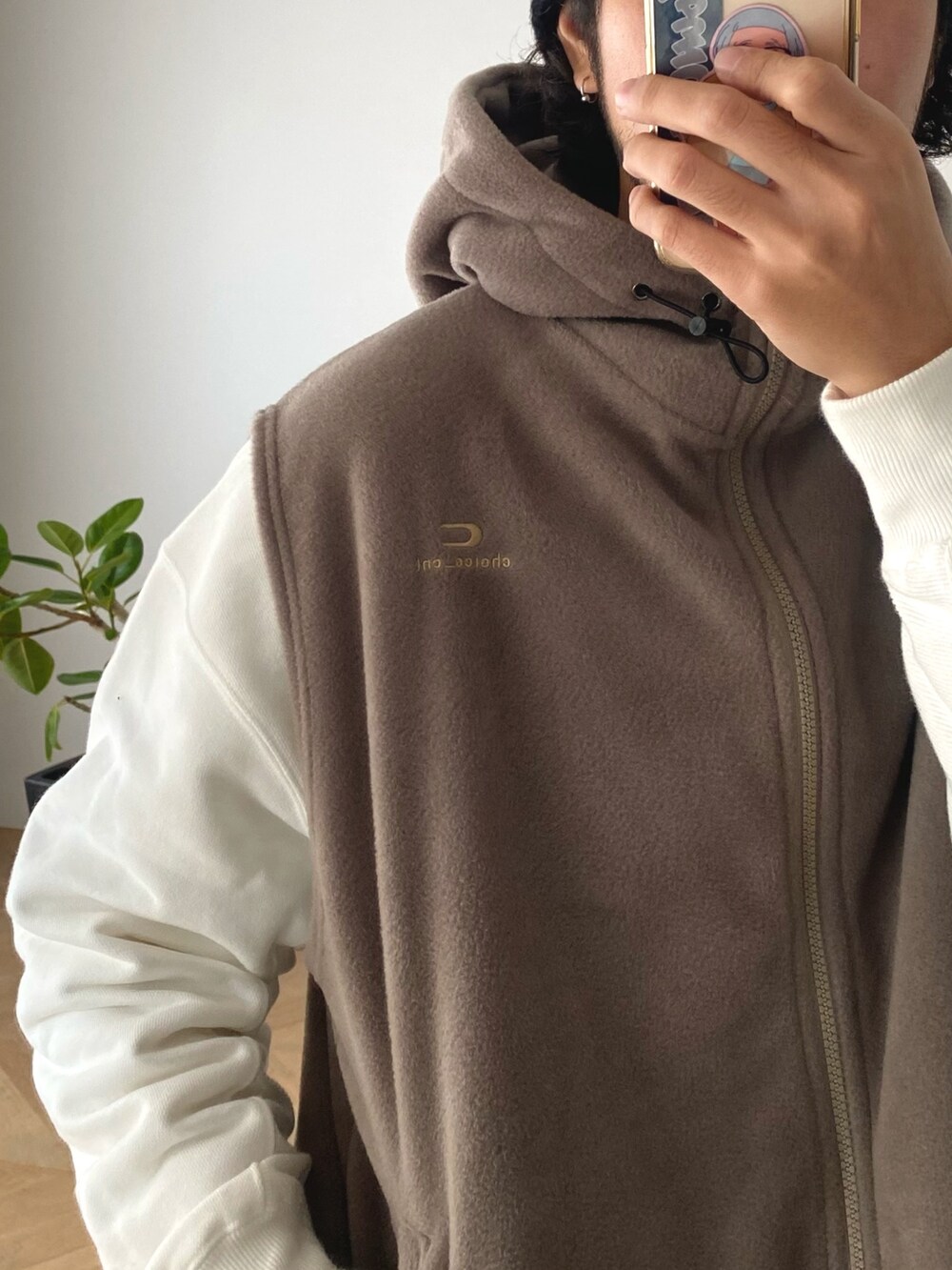 ホワイト系のスウェット、ベージュ系のベスト、ブラック系のその他パンツを着用したメンズの冬コーディネートの2枚目の写真