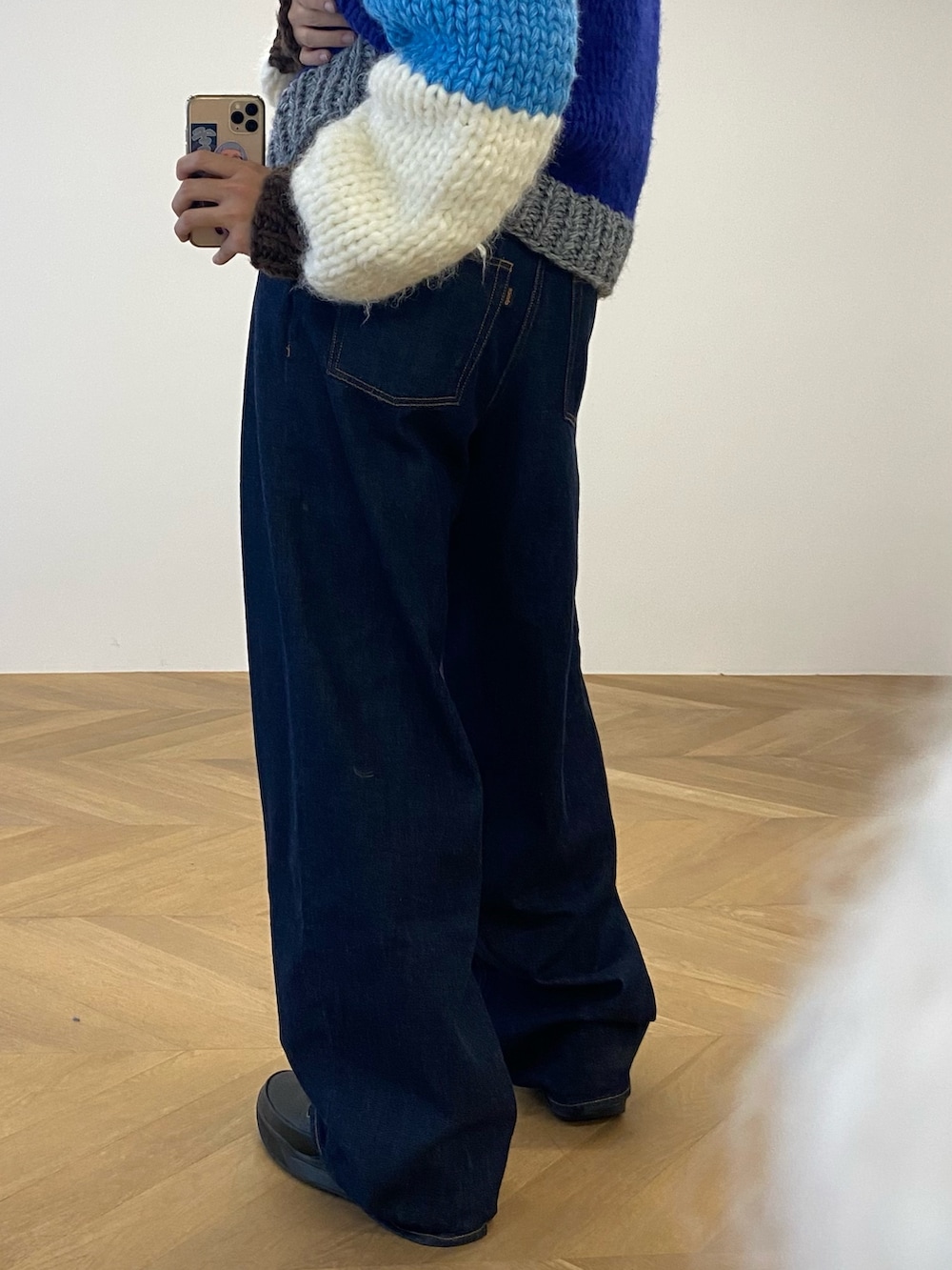 ブルー系のニット/セーター、ブルー系のデニムパンツ、ベージュ系のTシャツ/カットソーを着用したメンズの冬コーディネートの3枚目の写真