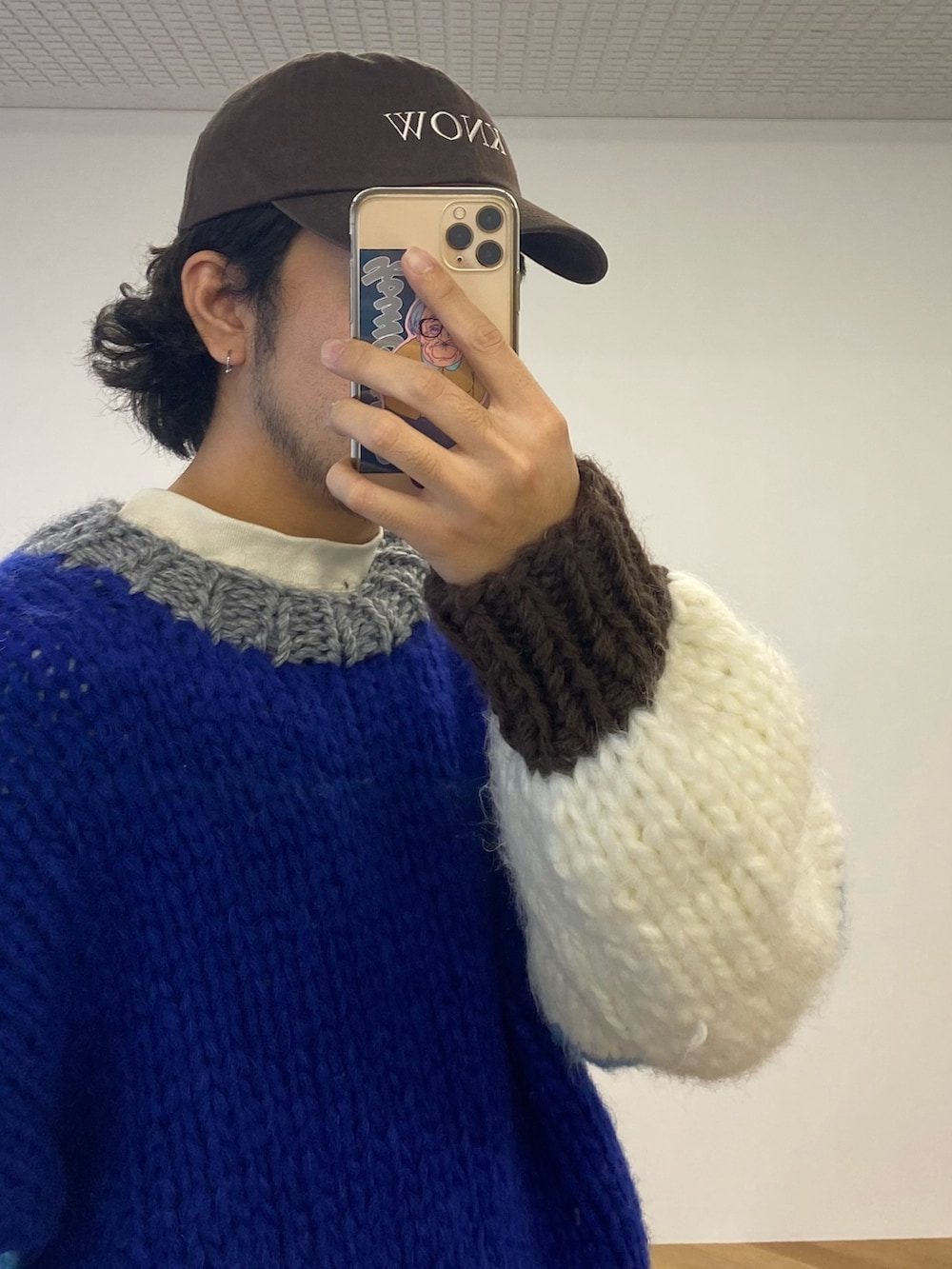 ブルー系のニット/セーター、ブルー系のデニムパンツ、ベージュ系のTシャツ/カットソーを着用したメンズの冬コーディネートの2枚目の写真