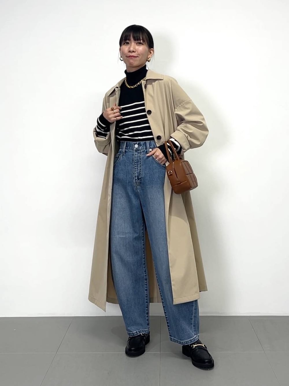 ブラック系のローファー、ブラック系のニット/セーター、ブラウン系のハンドバッグを着用したレディースの冬コーディネートの4枚目の写真