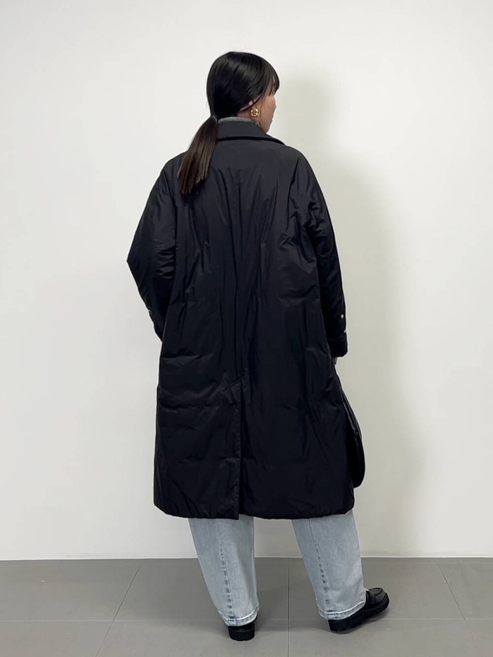 ブラック系のローファー、ブラック系のその他アウター、グレー系のニット/セーターを着用したレディースの冬コーディネートの2枚目の写真