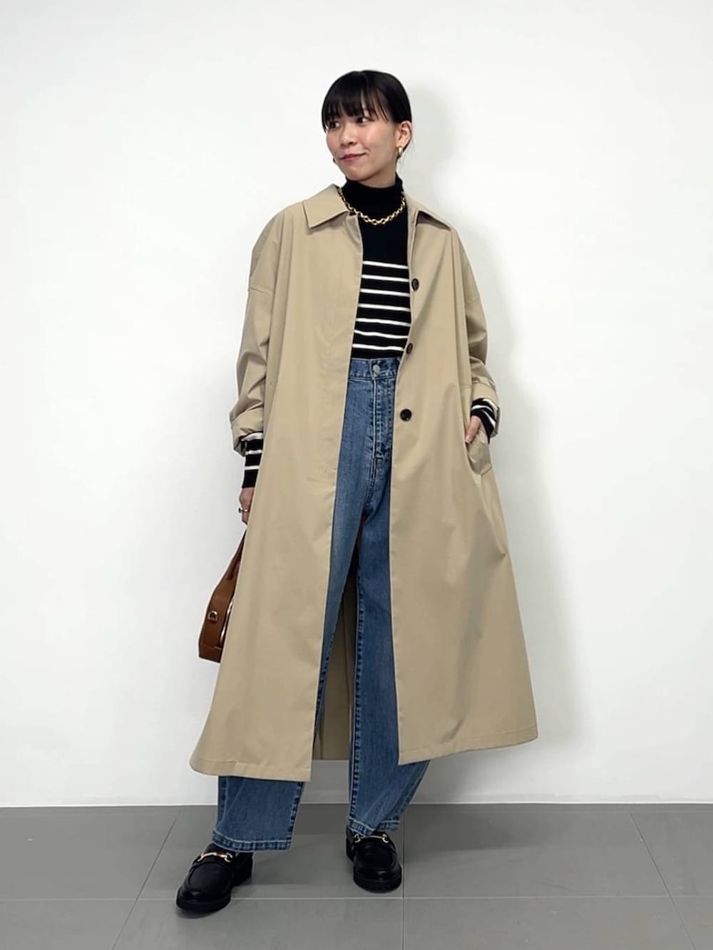 ブラック系のローファー、ブラック系のニット/セーター、ブラウン系のハンドバッグを着用したレディースの冬コーディネートの2枚目の写真