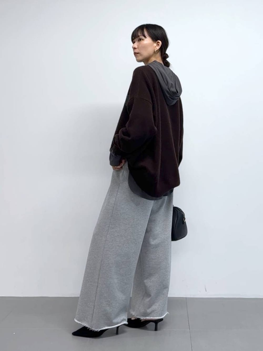 グレー系のTシャツ/カットソー、ブラック系のボストンバッグ、ブラック系のパンプスを着用したレディースの秋コーディネートの3枚目の写真