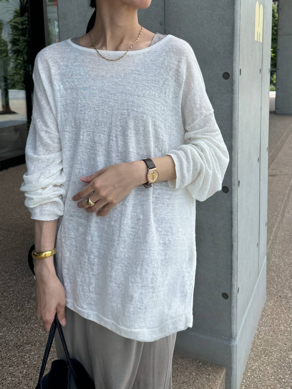 ホワイト系のニット/セーター、ベージュ系のスカート、ベージュ系のタンクトップを着用したレディースの夏コーディネートの3枚目の写真