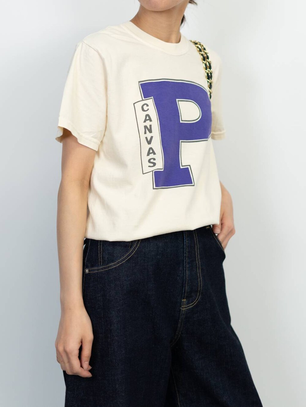 ブラック系のローファー、ブラック系のショルダーバッグ、ブルー系のデニムパンツを着用したレディースの春コーディネートの4枚目の写真