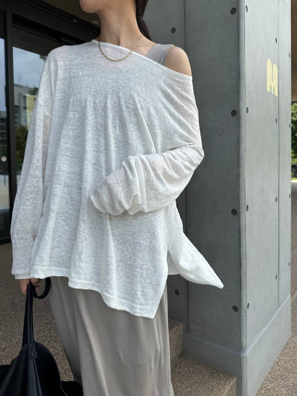 ホワイト系のニット/セーター、ベージュ系のスカート、ベージュ系のタンクトップを着用したレディースの夏コーディネートの2枚目の写真