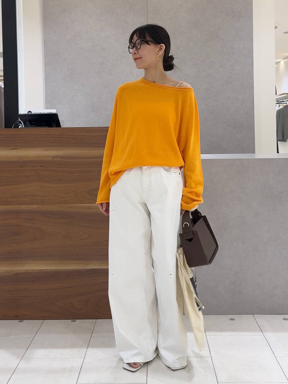 ブラウン系のハンドバッグ、ホワイト系のデニムパンツ、ホワイト系のキャミソールを着用したレディースの春コーディネートの3枚目の写真