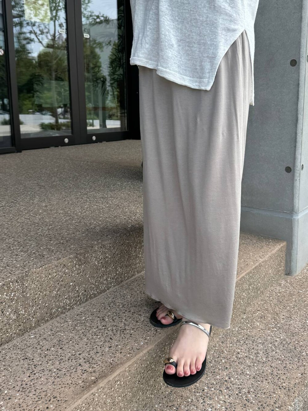 ホワイト系のニット/セーター、ベージュ系のスカート、ベージュ系のタンクトップを着用したレディースの夏コーディネートの7枚目の写真